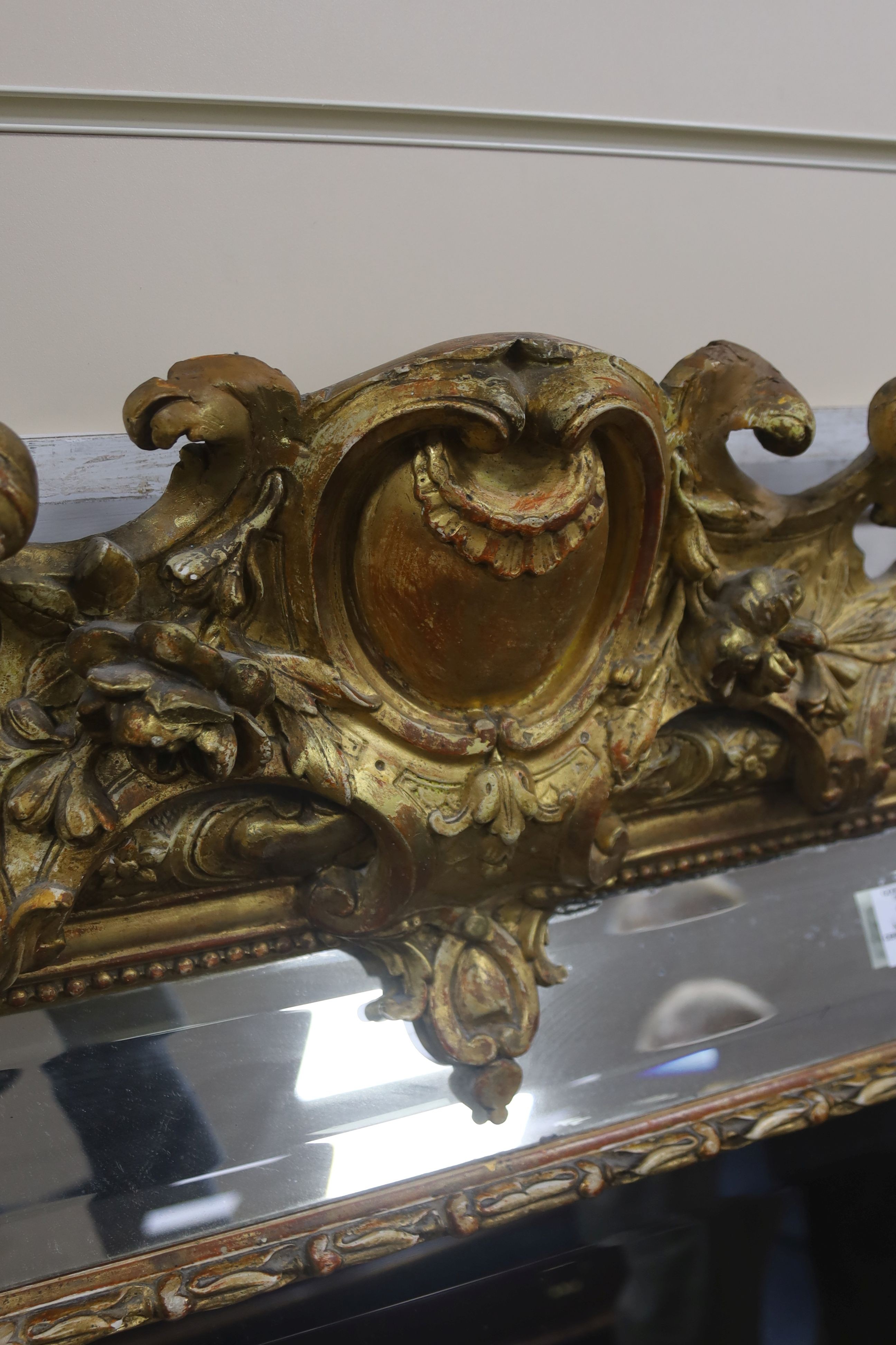 A large 19th century French gilt and gesso frame, bevel edged mirror with cushion margin, plated and C scroll, width 108cm, height 137cm